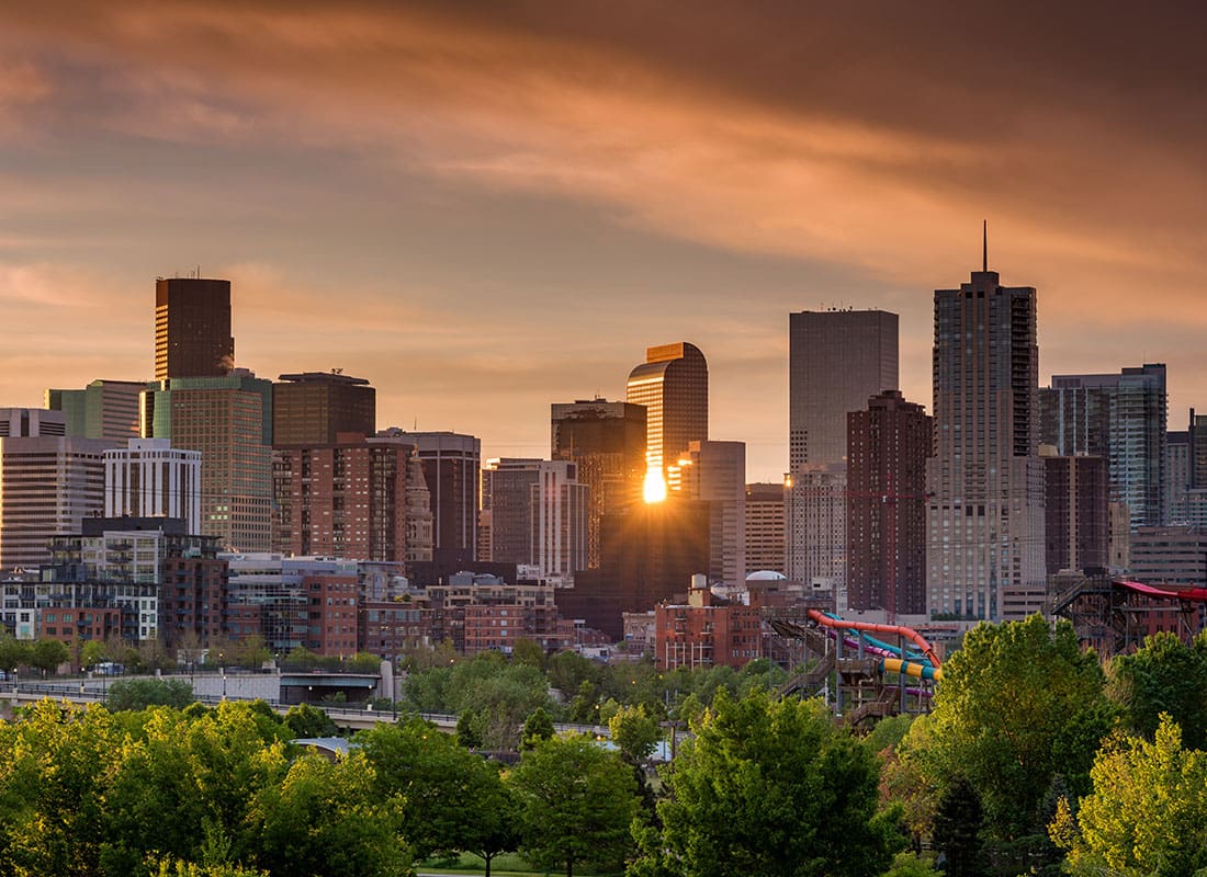 Denver, CO - Downtown Denver Colorado Skyline with Buildings Against a Colorful Sunset Sky